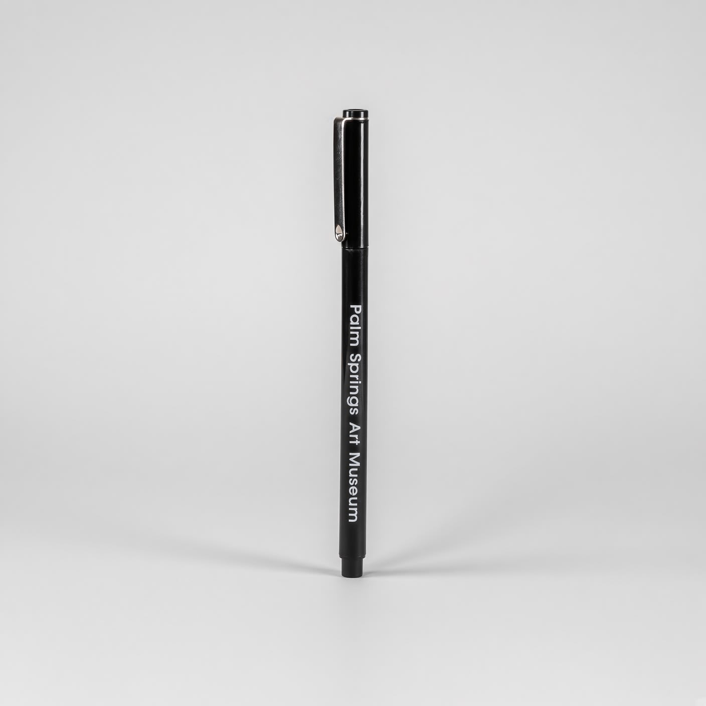 Black capped pen standing on end, with Palm Springs Art Museum in white along the barrel.