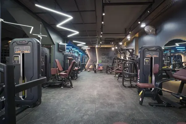 Premium gym interior with sophisticated lighting and restrained material palette