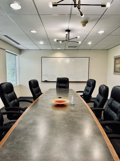 Spacious boardroom with long table and comfortable chairs, seats 12+