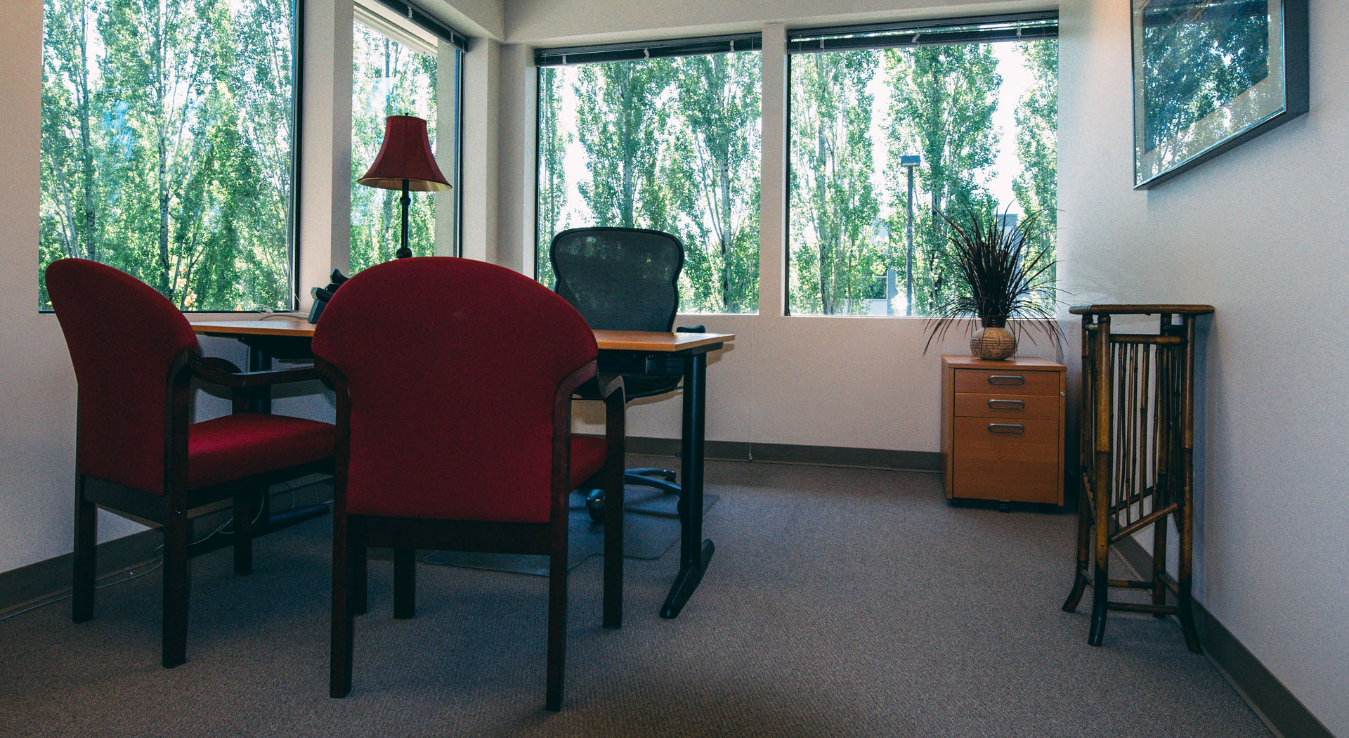 Private office with a red chair and window view