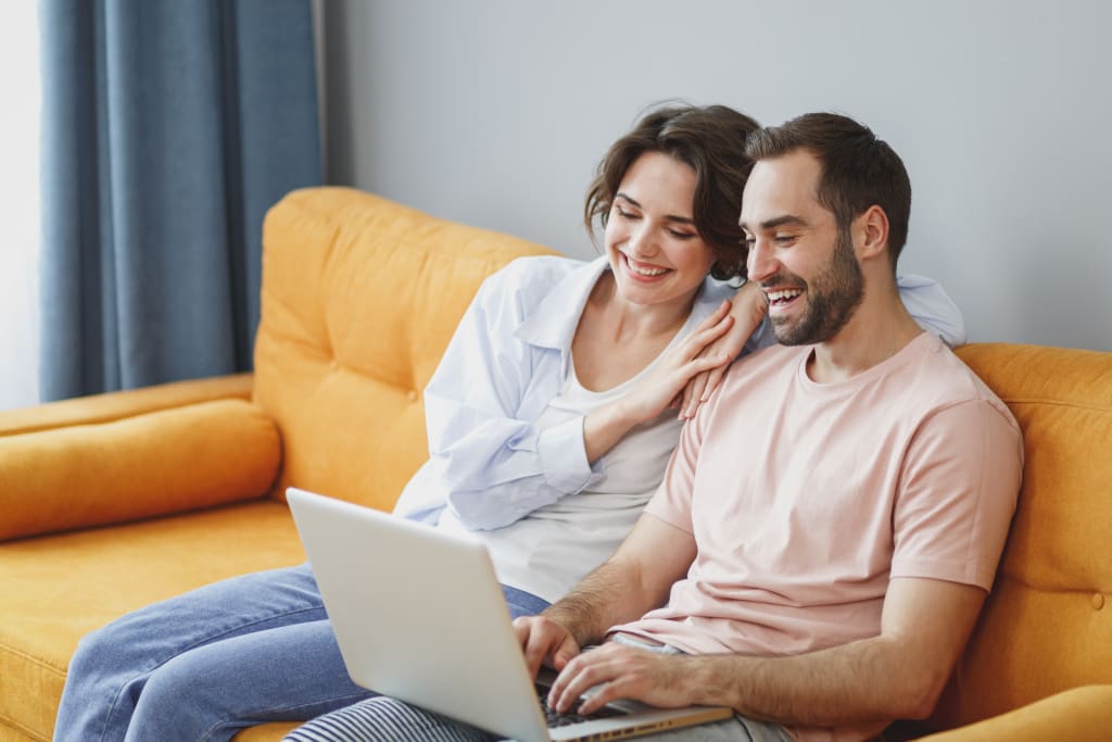 coppia sul divano che utilizza pc