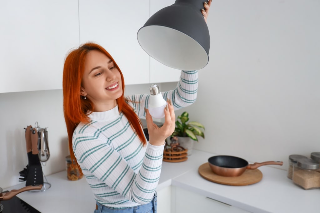 Ragazza cambia lampadina Ragazza cambia lampadina