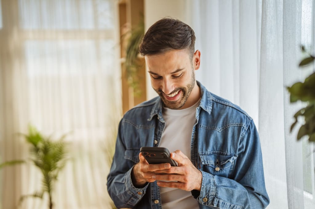Ragazzo sorride al cellulare Ragazzo sorride al cellulare