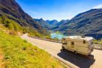 camper_su_strada_in_mezzo_alle_montagne