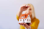 donna_che_protegge_una_casa_modello_in_miniatura