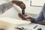 Mani di due uomini che si scambiano le chiavi dell'auto