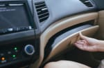 persona apre cruscotto auto per prendere documenti