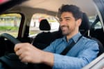 uomo sorridente guida auto