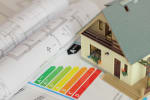 Certificazione energetica appoggiata accanto al modellino di una casa