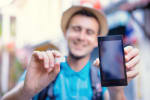 giovane mostra una sim e uno smartphone