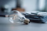 Lampadina accanto a bollette Lampadina accanto a bollette