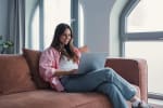 Ragazza al computer sul divano di casa
