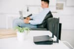 router nero sulla scrivania e uomo che utilizza il pc