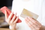 Persona tiene carta di credito in mano Persona tiene carta di credito in mano