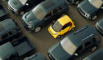 city car gialla parcheggiata tra suv