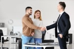 consulente e clienti che si stringono la mano in ufficio