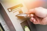mano inserisce carta di credito in sportello bancomat