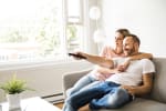 coppia che guarda tv seduta sul divano