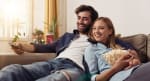 coppia di ragazzi che guarda la tv sul divano