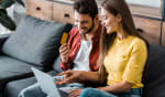 coppia felice al pc con carta di credito in mano