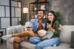 coppia guarda la tv sul divano