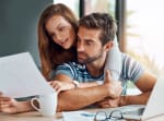 coppia legge foglio seduti alla scrivania