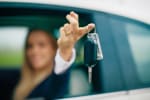 Donna al volante che tiene le chiavi dell'auto in mano