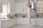 donna cambia lampadine in cucina
