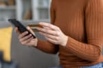 Donna che controlla transazioni con carta di credito in mano