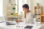 Donna che utilizza il computer e fa dei calcoli
