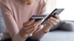 Donna con carta di credito e telefono