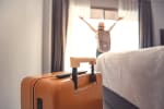 Donna appena arrivata in hotel che apre la finestra