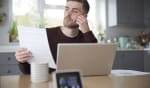ragazzo al pc legge un foglio