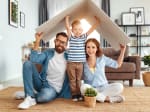 Famiglia felice gioca in casa con tetto di cartone
