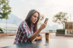 giovane donna digita un messaggio di testo sullo smartphone