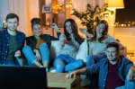 Gruppo di amici in casa la sera che guarda la televisione Gruppo di amici in casa la sera che guarda la televisione