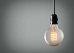 Lampadina accesa su sfondo grigio