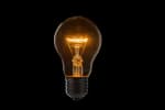 Lampadina accesa su sfondo nero