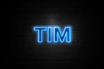 logo neon tim su muro di mattoni