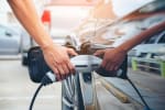 mano che ricarica auto elettrica