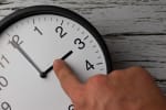 mano che sposta le lancette dell'orologio