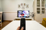 mano che utilizza telecomando per pay tv