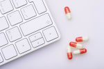 Medicinali accanto alla tastiera del computer
