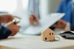 modellino di casa in legno su tavolo di ufficio finanziario