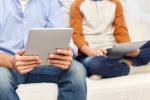padre e figlio che navigano in internet con diversi dispositivi