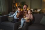 Papà con bambini che guardano tv Papà con bambini che guardano tv