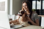 ragazza al pc con cane in braccio