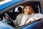 Ragazza al volante che guarda fuori dal finestrino dell'auto