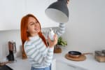 Ragazza che cambia lampadina