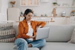 Ragazza che naviga in internet seduta sul divano di casa